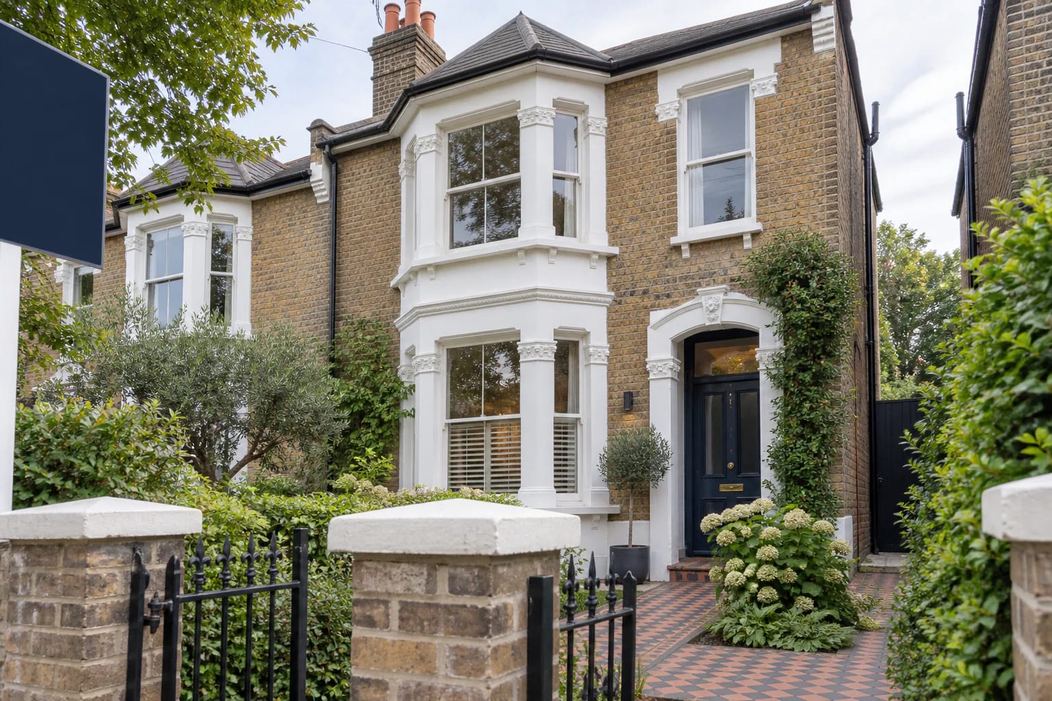 For Sale board outside a period home on a tree-lined South London street
