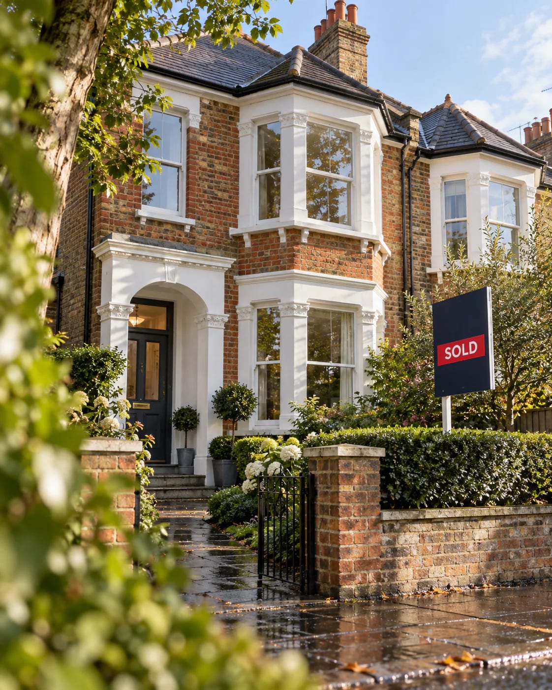 Sold board outside a period family home on a leafy South London street